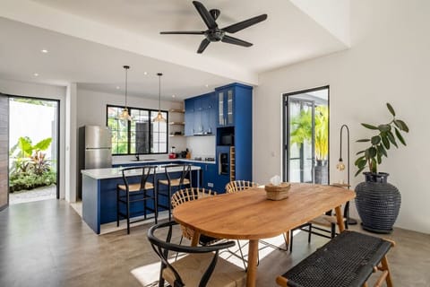 Spacious dining and kitchen area with a pop of blue and ample natural light.