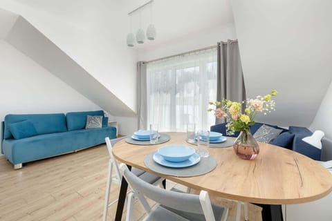 A bright living room with a comfortable blue sofa, wooden coffee table, and subtle decorations creates a cozy space for relaxation.