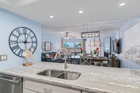 Open-concept living space w/ comfortable seating, large wall clock, and room to gather.