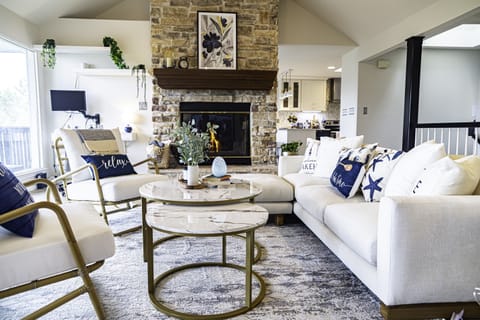 At the heart of the room, a stone fireplace stands as a focal point, its crackling flames casting a warm, inviting glow on chilly evenings. 