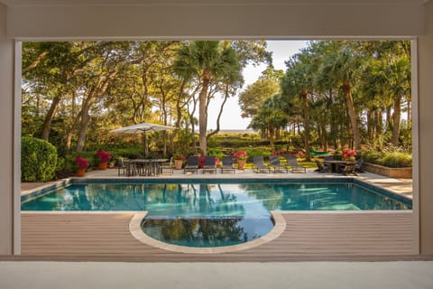 The vast living area unfolds before you, seamlessly extending to an inviting pool, sun-kissed deck, and a private pathway that leads directly to the  beach.