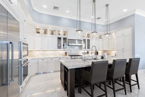 Custom white kitchen cabinets pop against pale blue walls.