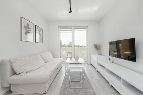 Stylish and bright living room with sofa bed, TV and access to the balcony.