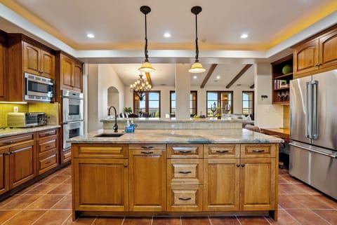 Expansive granite top two-tiered island with built in sink and p