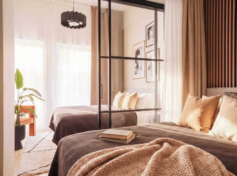 An innovative layout creates two separate bedrooms using elegant glass partitions and full-length privacy curtains, offering the perfect balance of openness and comfort.