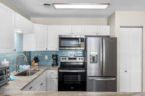 Fully equipped kitchen featuring a double-door refrigerator, microwave, oven, stove, dishwasher, coffee maker, and all the essentials needed to prepare delicious meals during your stay