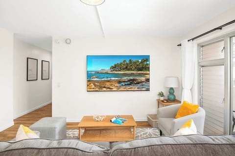 Living room with a queen-size pull-out sleeper sofa, a 75'' smart TV, and a beautiful mountain view.