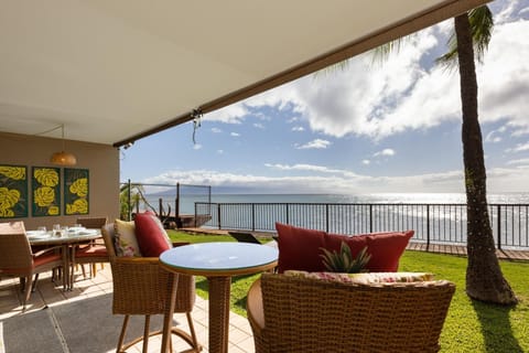 Relax on this private lanai with comfortable wicker chairs and vibrant cushions, all set against a backdrop of crystal-clear ocean waters.