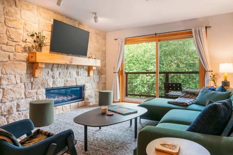 The main living area has a cozy stone fireplace and tons of natural light!