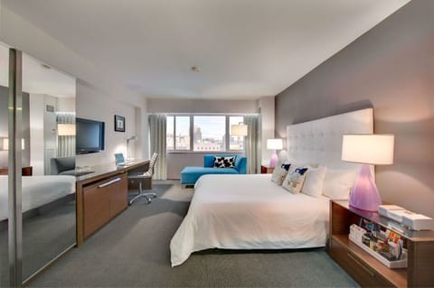 Spacious and well-lit room featuring contemporary furnishings and soothing color tones, perfect for a comfortable stay.