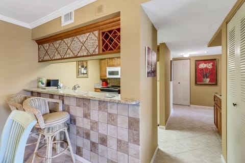 An eating bar with 2 bar stools separates the kitchen from the dining area.