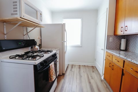 Kitchen with stove, refrigerator and microwave oven. 