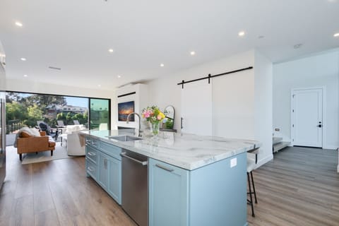 Charming kitchen escape: White cabinets, blue island, and wooden accents.