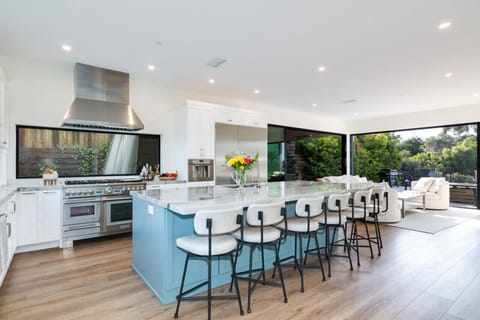 Kitchen charm featuring white cabinets, steel appliances, 6 seater island bar —where flavors and style meet.