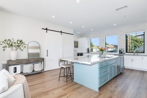 Charming kitchen escape: White cabinets, blue island, and wooden accents.