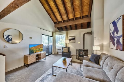 Unwind beneath stunning exposed wooden beams in your cozy living space, where modern comfort meets rustic charm and natural light streams through large windows.