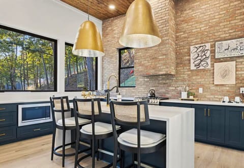 Rise and shine to a wooded view in our sleek kitchen where the great outdoors meets modern comfort. The perfect setting for a tranquil breakfast.