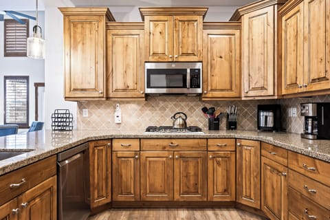 - Modern kitchen with wood cabinetry and granite tops  
- Stainless steel microwave and gas cooktop included  
- Fully equipped cooking area for all your meals