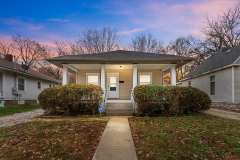 Charming front exterior with covered porch at twilight at Cairo St Bungalow, Springfield, MO—inviting curb appeal for guests seeking comfortable temporary housing