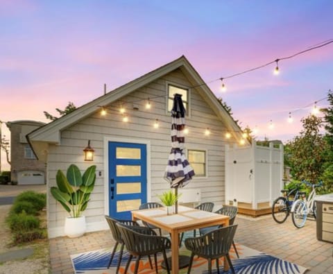 Unwind in this beautifully lit outdoor seating area, complete with a dining set, string lights, and a hot tub for perfect evenings.