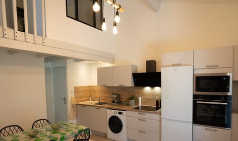 Air-conditioned living room with fitted kitchen, dining table and TV.