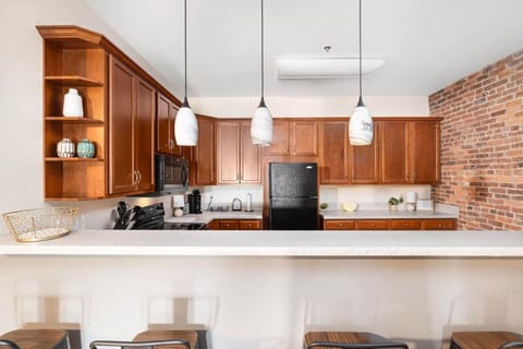 Gather around the sleek bar seating, a perfect spot for casual meals, drinks, or chatting with the chef while enjoying the open layout.