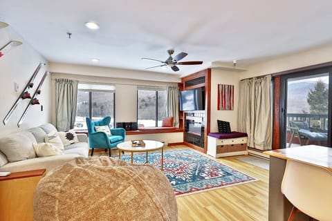 Renovated 2-bedroom, 2-bathroom condo at Mountain Green Resort in Killington, Vermont. Its living room features a sofa bed, stylish furnishings, an electric fireplace, smart TV with streaming services, and breathtaking mountain views.