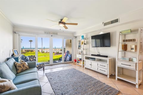 - Catch the game or your favorite shows on the flat screen TV, framed by ocean views
- Step right out to the grassy lawn or lounge inside in comfort with a breeze from the fan
- Stylish shelving and decor give the room a playful, welcoming vibe
