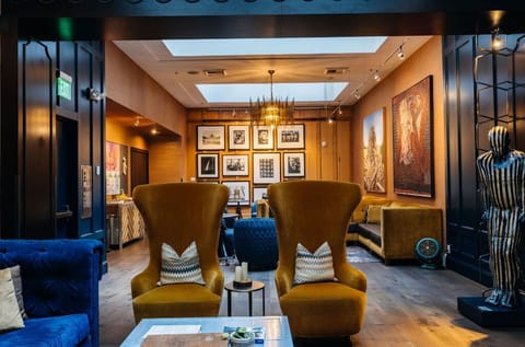 Our lobby is designed to make a grand statement, featuring dramatic ceilings, plush sofas, and armchairs, all set against a backdrop of dark wood paneling.