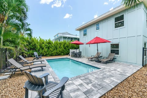 Pool in backyard with plenty of loungers and seating