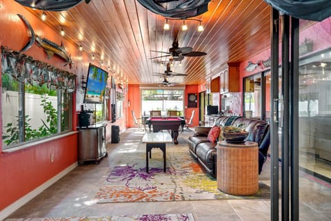 Game room featuring gaming system and a mounted TV- stocked mini fridge w drinks