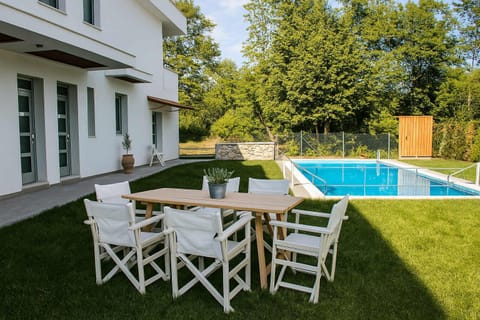 Exterior seating area – Garden furniture under trees, ideal for dining or morning coffee.

