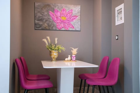 Bright and Stylish Dining Nook with Bold Art and Magenta Seating
A thoughtfully designed corner featuring a modern white table, vibrant purple chairs, and a striking floral painting — perfect for relaxed meals or morning coffee.