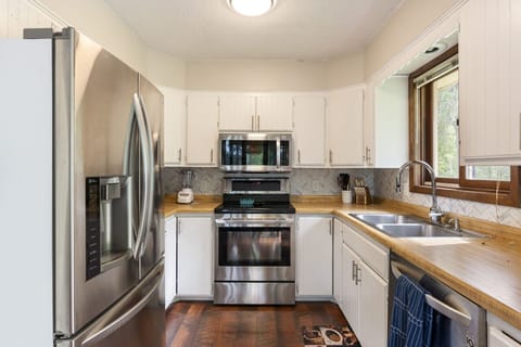 Bright kitchen area with a double sink and microwave oven.
