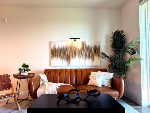 Spacious living room featuring a cozy sofa, two stylish armchairs, a full-size air mattress, and a 65" Smart TV with preloaded access to Netflix, Hulu, and Disney+, all set up for your enjoyment.