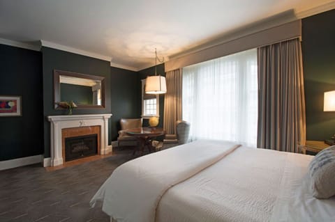 Rest peacefully in this elegant bedroom featuring a comfortable bed, cozy fireplace, and plenty of natural light.