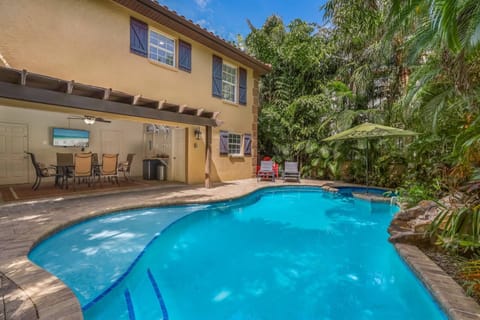 Large heated pool has tanning deck and swim up bar