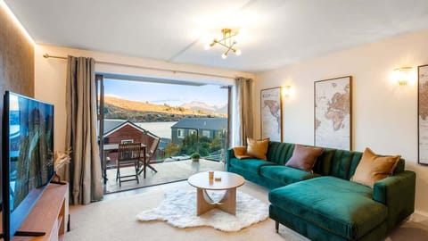 Relax in the cozy living room, complete with a lake-view backdrop, contemporary decor, and ample natural light.