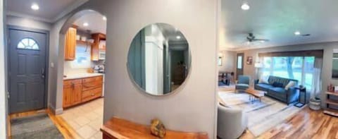 Step into comfort and charm! This panoramic view highlights the inviting entryway, cozy living space, and a peek into the fully equipped kitchen.