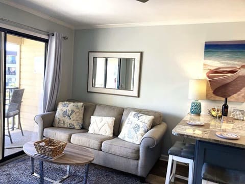 A cozy space featuring a light gray sofa adorned with nautical-themed throw pillows.