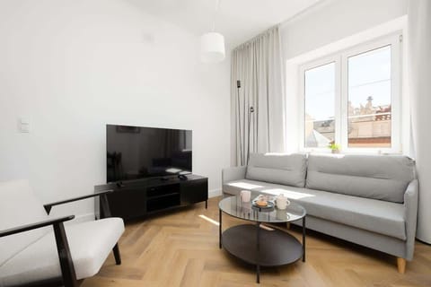 A bright living room with a large window and minimalist decor offers space to relax and access to natural light throughout the day.