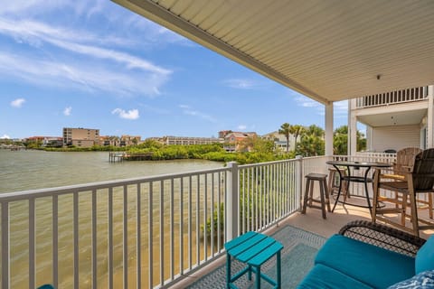 Relax on the private balcony w/ seating & peaceful water views beyond the railing.