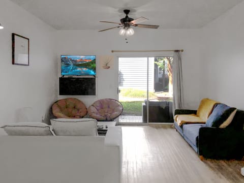 Spacious living room, 9-foot ceiling, access to patio, blue sofa-bed, Roku TV.