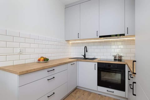 Well-equipped kitchen with oven, stove, and essential utensils.