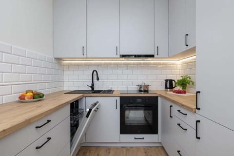 Modern kitchen with bright furniture and high-quality appliances.