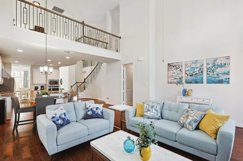 This sophisticated living room has high ceilings, chic décor, and modern furniture to create a lively but relaxed space for you to call your home away from home.