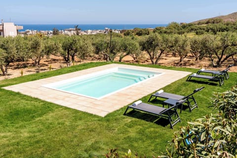 A peaceful poolside setting surrounded by nature, with the coastline just beyond.