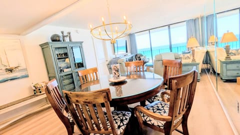 Enjoy the open-concept living and dining area, perfectly framed by breathtaking floor-to-ceiling beachfront views.