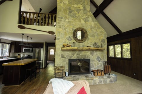 Cozy up by the stone fireplace while staying connected to the fully equipped kitchen—perfect for family gatherings!