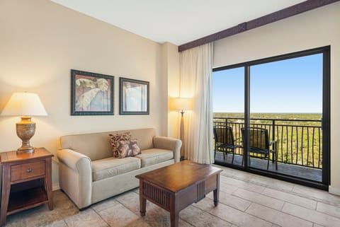 Relax in this cozy living room with balcony views of the surrounding landscape.